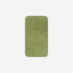 Top view of a green organic cotton face towel laid flat with rounded corners, shown on a white background.