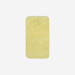 Top view of a yellow cotton face towel laid flat with rounded corners, shown on a white background.
