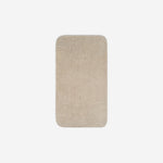 Top view of a light cream organic cotton face towel with rounded corners, displayed flat on a white background.