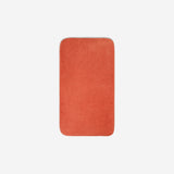 Top view of an orange organic cotton face towel with rounded corners, displayed flat on a white background.