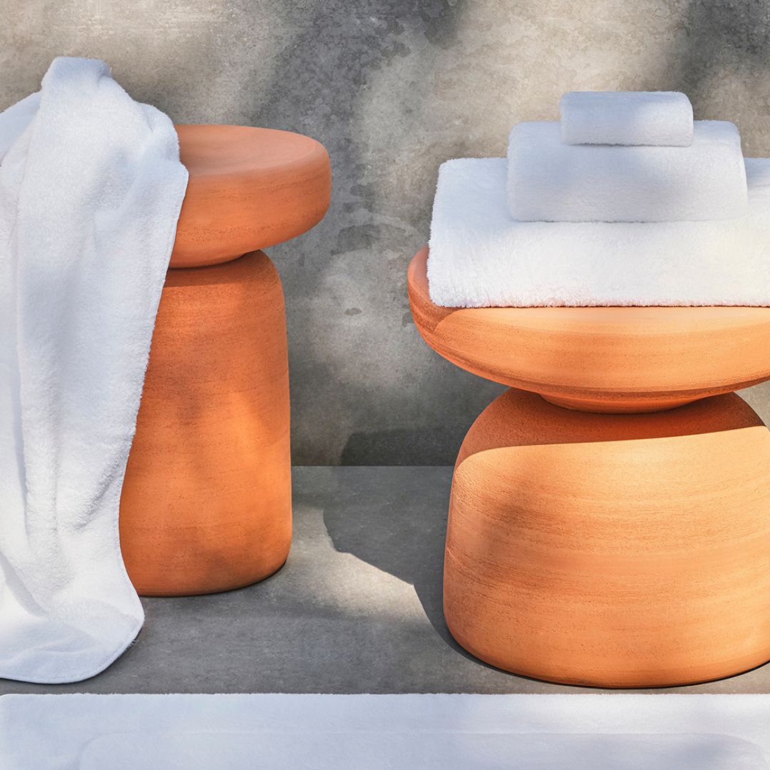 White bath towels displayed on terracotta stools